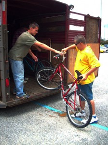 <span class='credit'>Photo By: Kelsey A. Schnell | Editor in Chief</span><span class='description'>Brotherly Love: Jesse Spindlow (L) helps his younger brother Amos load one of the dozens of bike into the trailer.</span>