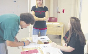 Cross Our Hearts: Nicole Johns helps a student register to donate at a previous Red Cross blood drive. Torch File Photo