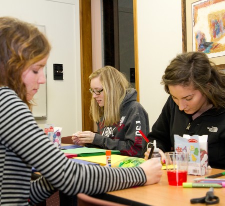 Spreading Holiday Cheer: Hannah Rillema, Jessica Swanson, and Emma Holmi, above from left to right, make holiday cards for soldiers overseas. Photo By: Brock Copus | Photographer