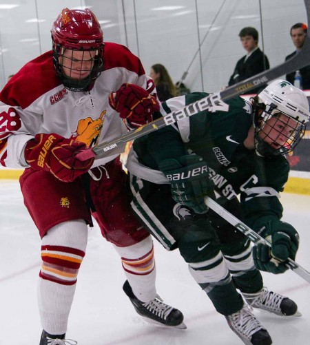 Entering the WCHA: Kyle Bonis, junior left wing, pushes past a Michigan State player during a 2010-11 season game. The Bulldogs will join the WCHA conference beginning in 2013. Torch File Photo