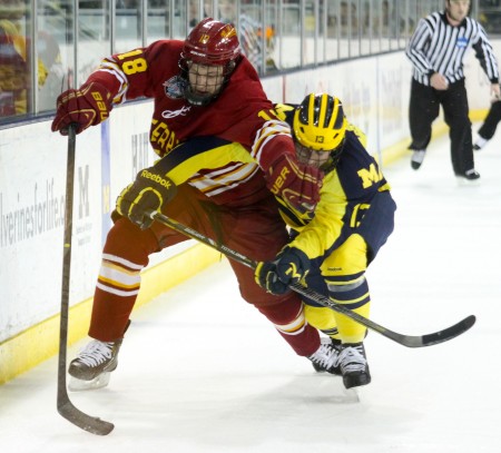 Keeping at Bay: Ferris junior left wing Andy Huff attempts to hold a Michigan attacker back. The Bulldogs would tie and lose the shootout against the Wolverines for the final regular season game. Photo by Brock Copus | Multimedia Editor