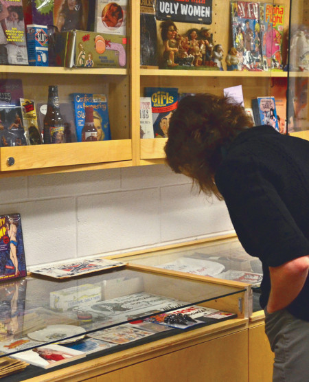 Tracy Busch, assistant professor of history, looks through a collection of objects representing sexism. The women’s collection is on display on the third floor of Starr.  Photo By: Brock Copus | Multimedia Editor