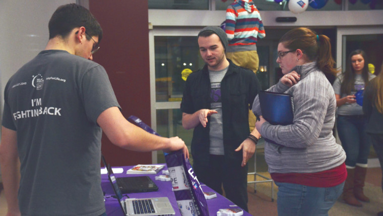 Travis Hodder, president of Colleges against Cancer (center), helps team leaders sign up and register for Relay for Life this past Thursday. At the kick off event, people were able to enjoy music, games and purchase Relay apparel.  Photo By: Olivia Odette | Photographer 