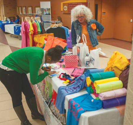 Local businesses offer t-shirts, blankets and other items as part of the Tribute to Women Expo. A discussion panel was held about women and gender roles in the work place. Photo By: Tori Thomas| Photographer