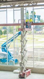 Construction workers put the finishing touches on the windows of the new University Center that will open in January 2015.