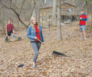 Former Torch News Editor Taylor Hooper helps out by raking leaves in the community during last year’s Big Event.