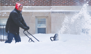 Patrick Patterson clears the sidewalks on Monday, Feb. 2, 2015, in front of the Parkhurst Apartments in Detroit’s West Village after a snow storm dumped more than a foot on the city and surrounding areas since Sunday. Photo was taken on February 2, 2015.