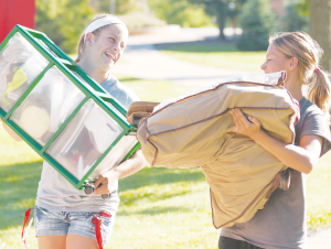 In this file photo, a Resident Advisor (RA), helps one of her residents move into her dorm room.