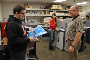 Professor Pat Klarecki assists graphic media management students Harold Burton and Autumn Brooks in the print lab.