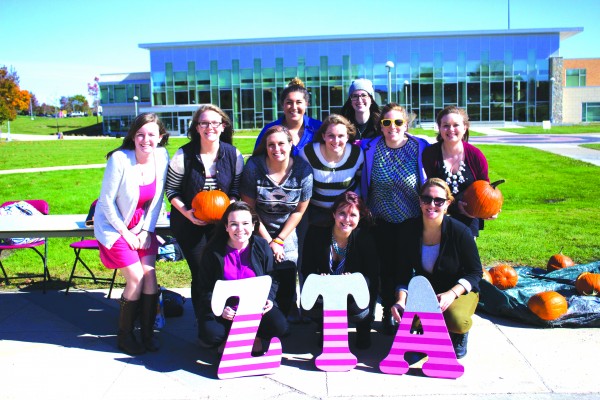 Zeta Tau Alpha poses in the Quad during their pumpkin smashing fundraiser for “Think Pink Week.”