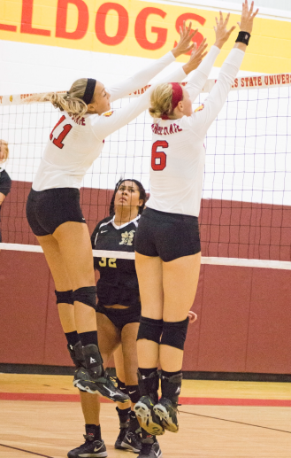 Sophomore Nicole Malouhos and senior Stephanie Sikorski leap to block an incoming spike.